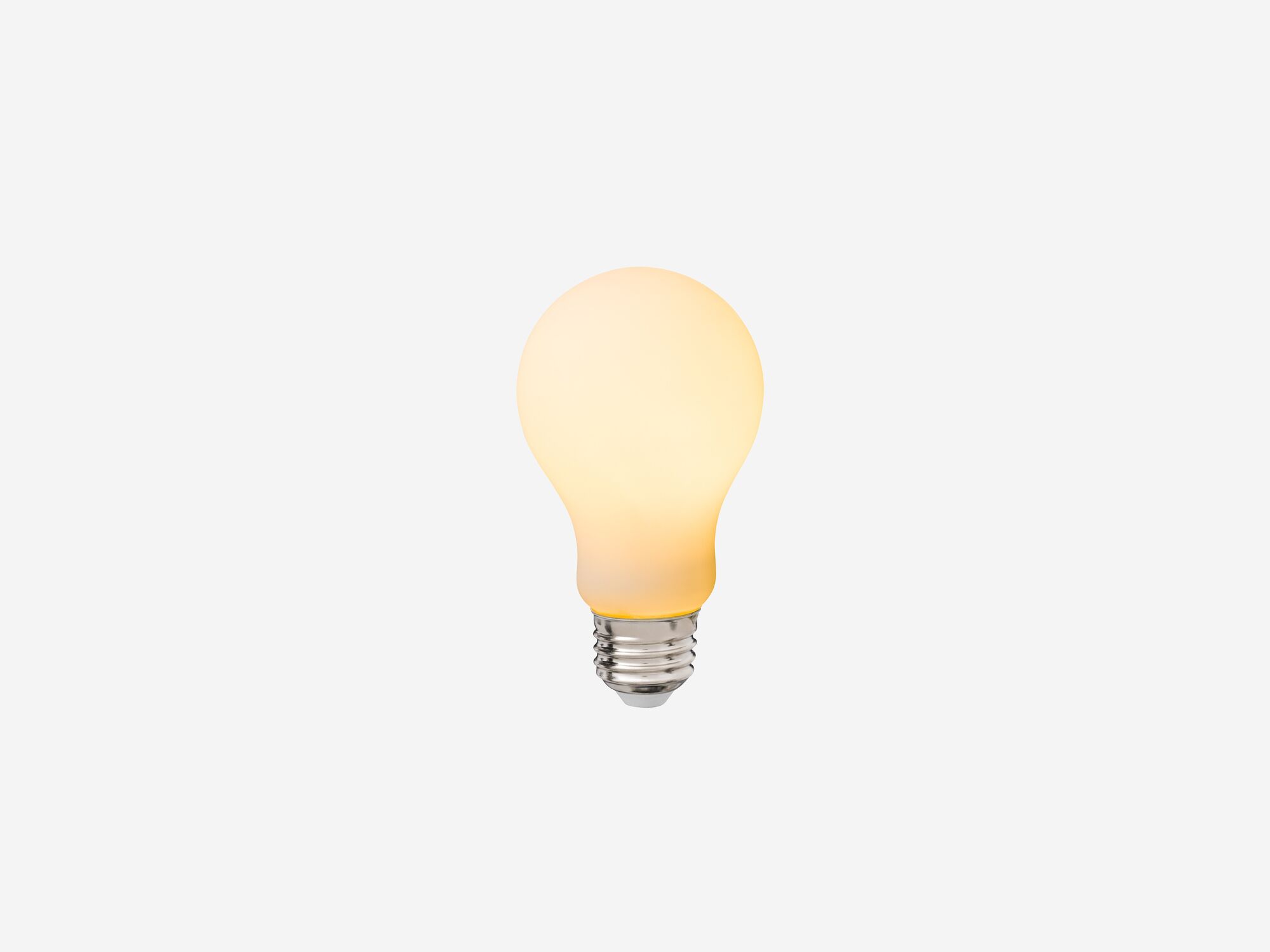 Front view of small matte white lightbulb with light on